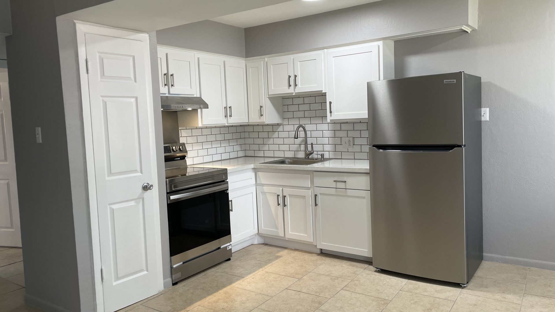 a kitchen with stainless steel appliances and a refrigerator at The HIllshire Village Apartments